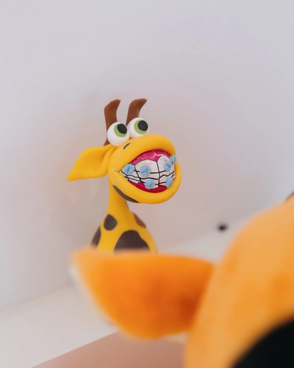 Mascote girafa com aparelho, atendimento infantil na Dra. Carolina Vivan